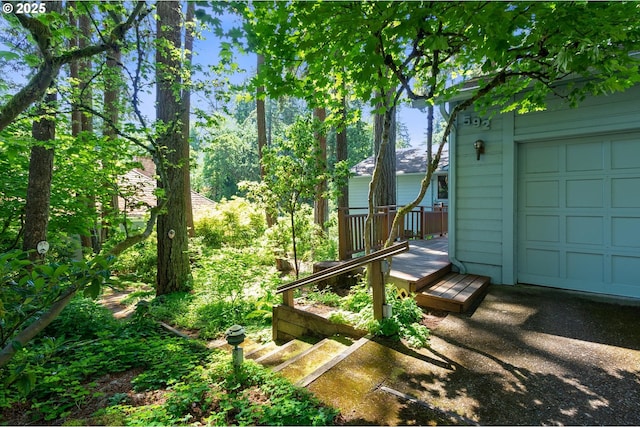 view of yard featuring a garage and a wooden deck