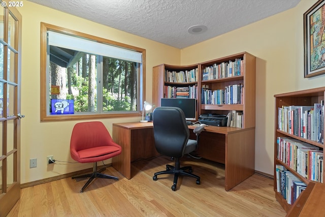 office with a textured ceiling, baseboards, and wood finished floors