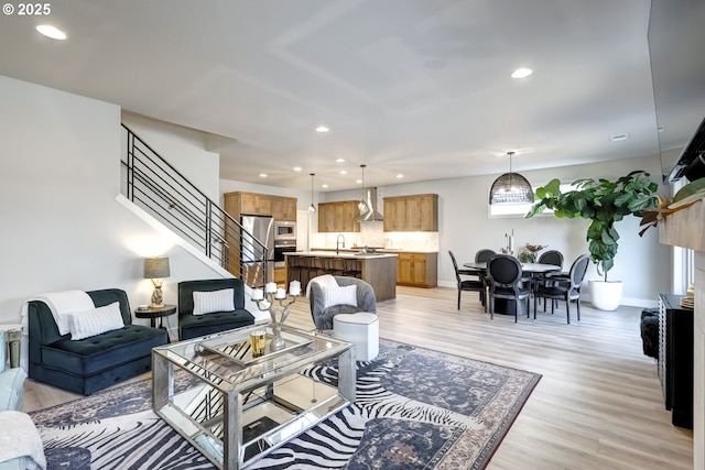 living room with sink and light hardwood / wood-style flooring