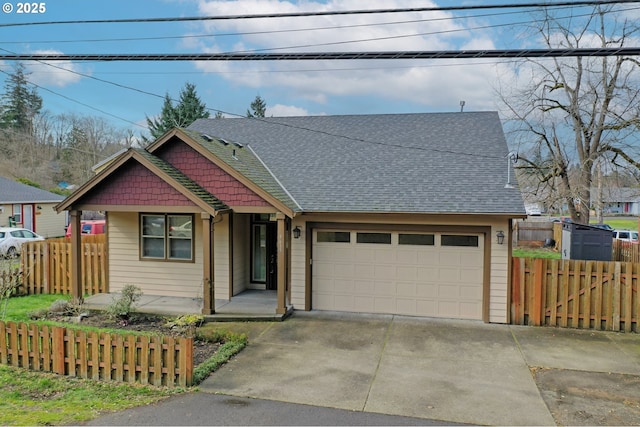 view of front of property with an attached garage, a shingled roof, driveway, and fence