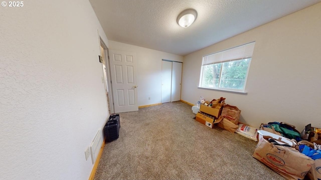 rec room with visible vents, baseboards, carpet floors, a textured wall, and a textured ceiling