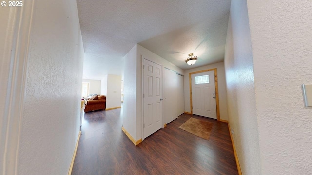 entrance foyer featuring wood finished floors, a textured wall, and a textured ceiling