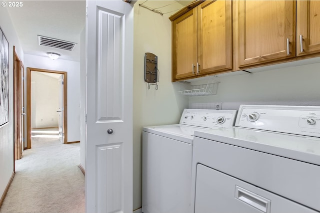 laundry area featuring cabinets, washing machine and dryer, and light carpet