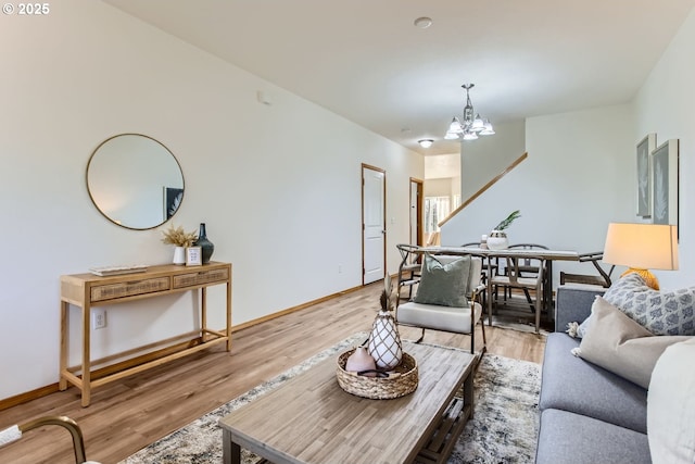 living room with a notable chandelier and light hardwood / wood-style flooring