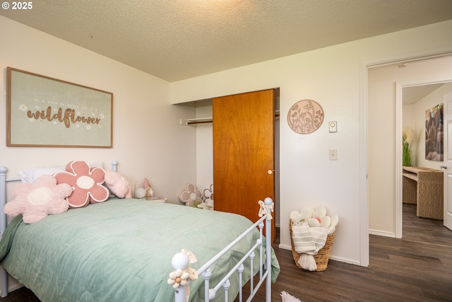 bedroom featuring baseboards, wood finished floors, and a closet