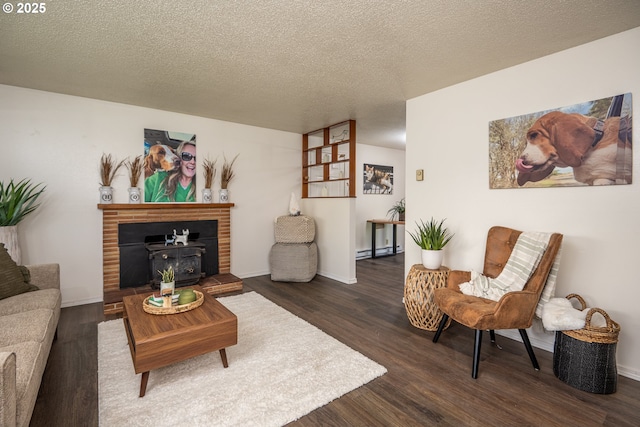 living area featuring a baseboard heating unit, dark wood-style flooring, a textured ceiling, and a fireplace