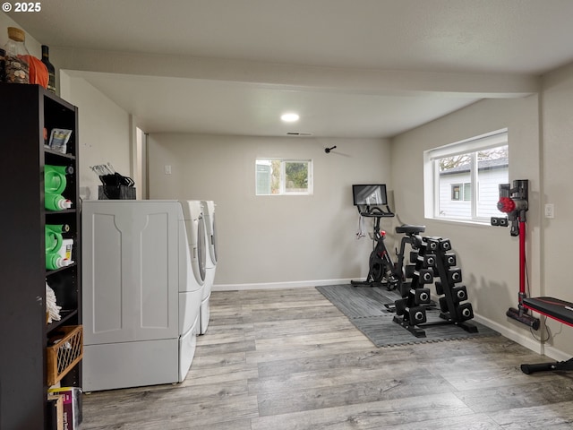 workout room featuring independent washer and dryer, plenty of natural light, and light hardwood / wood-style floors