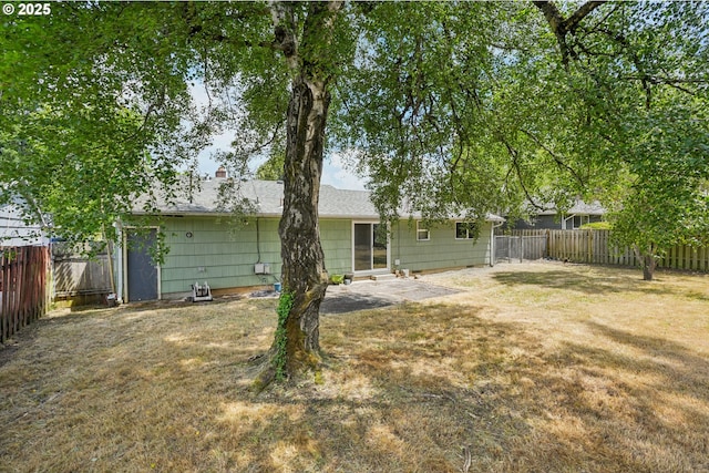 3259 SE 176th Pl, Portland, OR 97236 - back of property with a fenced backyard, a patio, and a chimney