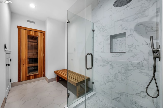 full bath featuring recessed lighting, baseboards, visible vents, and a marble finish shower