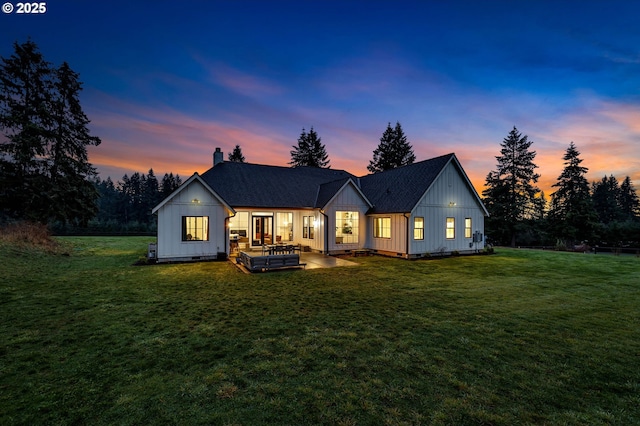 rear view of property with a yard, a shingled roof, crawl space, and board and batten siding