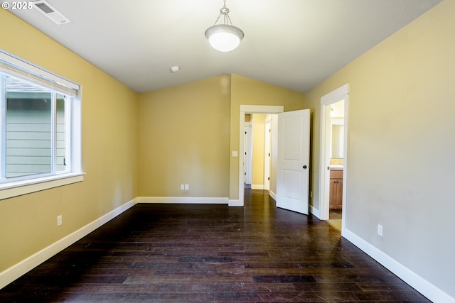 unfurnished bedroom featuring ensuite bath, vaulted ceiling, and dark hardwood / wood-style floors