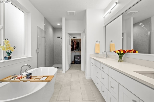 1046 SE Olive Way, Estacada, OR 97023 - bathroom featuring a stall shower, a freestanding tub, double vanity, tile patterned floors, and a spacious closet