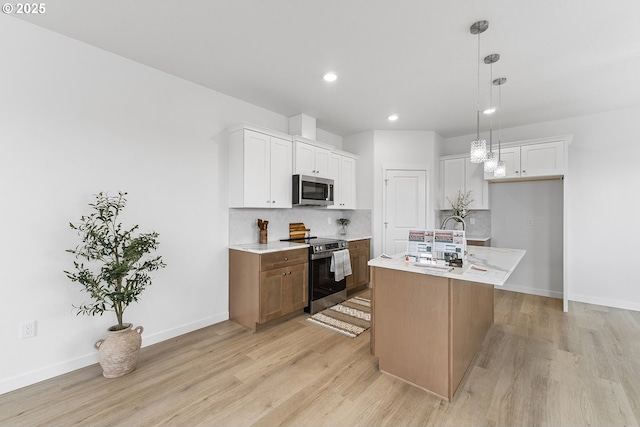 1129 NE Emerald Dr, Hermiston, OR 97838 - kitchen featuring stainless steel appliances, light wood finished floors, decorative backsplash, recessed lighting, and white cabinets