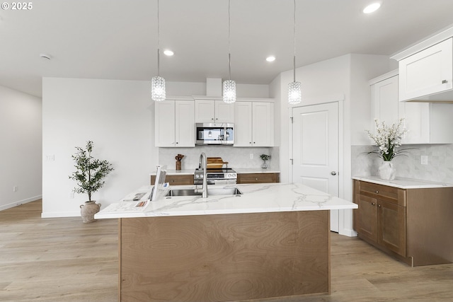 1129 NE Emerald Dr, Hermiston, OR 97838 - kitchen featuring stainless steel appliances, backsplash, light wood-type flooring, light stone counters, and recessed lighting