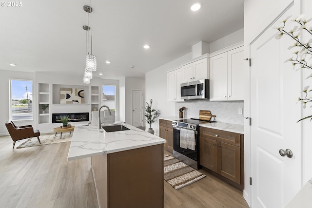 1129 NE Emerald Dr, Hermiston, OR 97838 - kitchen with stainless steel appliances, a sink, light wood-style floors, recessed lighting, and open floor plan