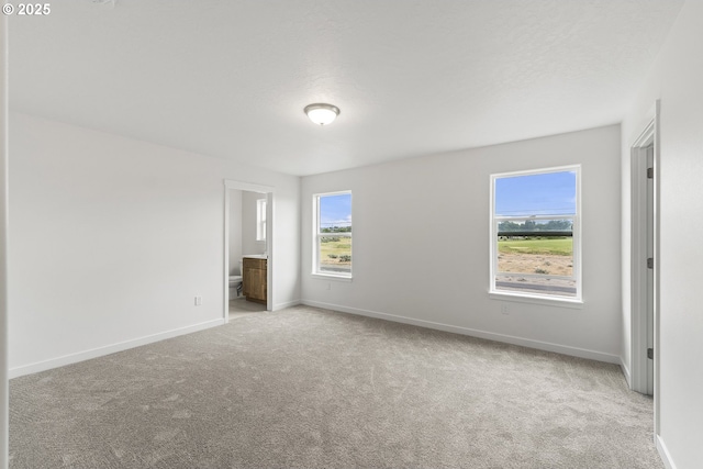 1129 NE Emerald Dr, Hermiston, OR 97838 - unfurnished bedroom featuring carpet, baseboards, and ensuite bathroom