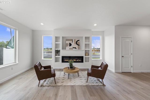 1129 NE Emerald Dr, Hermiston, OR 97838 - living room featuring wood finished floors, a glass covered fireplace, baseboards, recessed lighting, and built in features