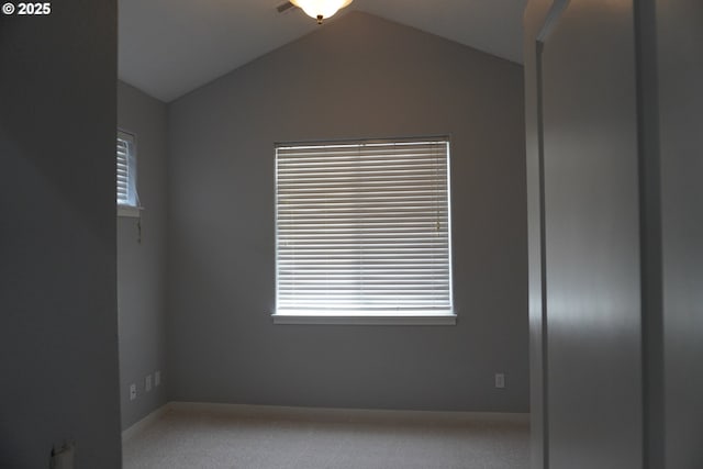 unfurnished room featuring lofted ceiling and light carpet