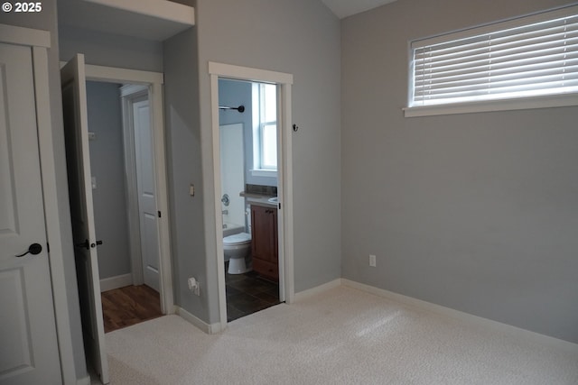 unfurnished bedroom with carpet and connected bathroom