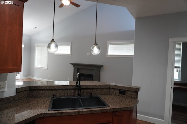 kitchen featuring decorative light fixtures, lofted ceiling, plenty of natural light, and sink