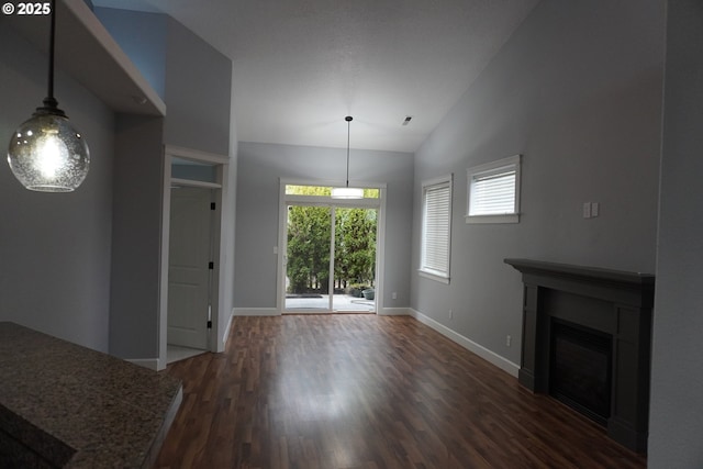 unfurnished living room with dark wood-type flooring and vaulted ceiling