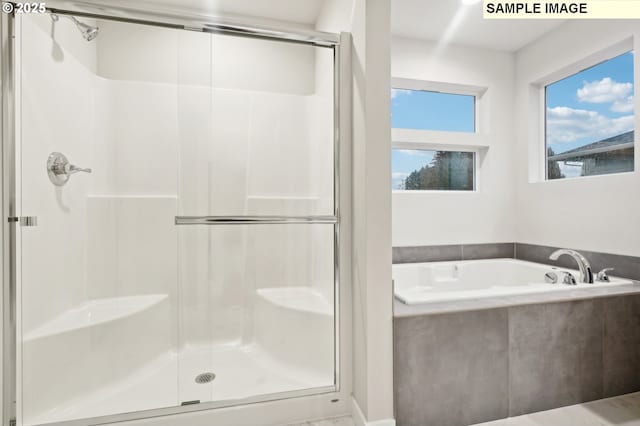 full bathroom featuring a stall shower and a garden tub