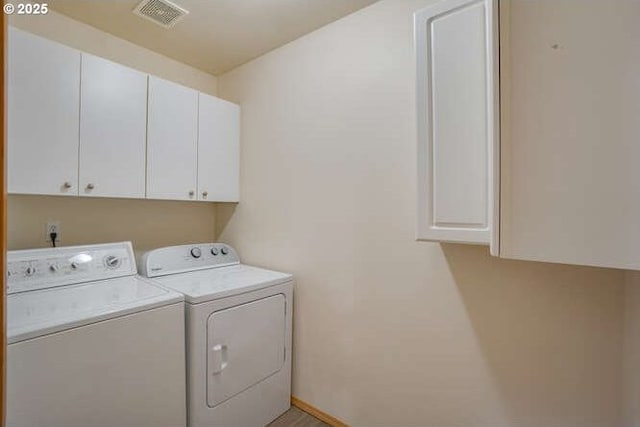 washroom featuring washer and clothes dryer and cabinets