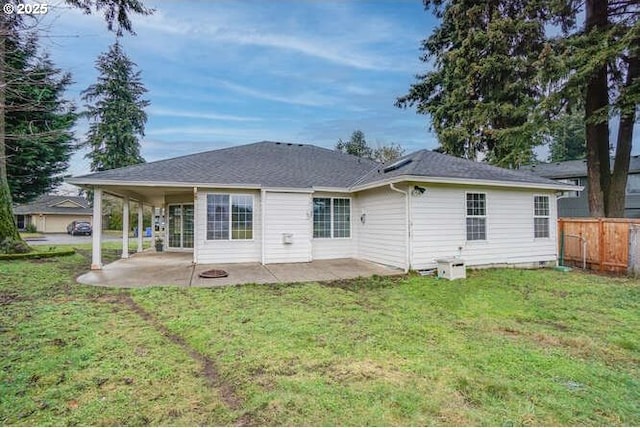 back of house with a patio area and a lawn