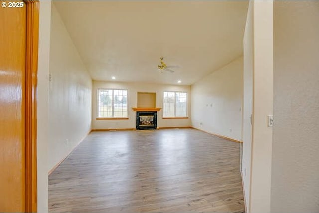 unfurnished living room featuring ceiling fan and light wood-type flooring