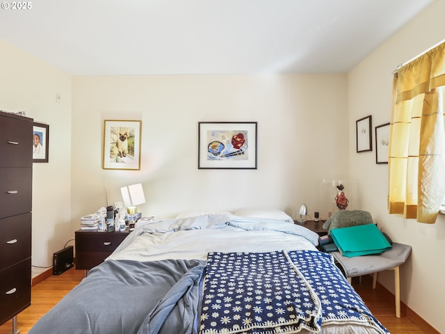 bedroom with baseboards and wood finished floors