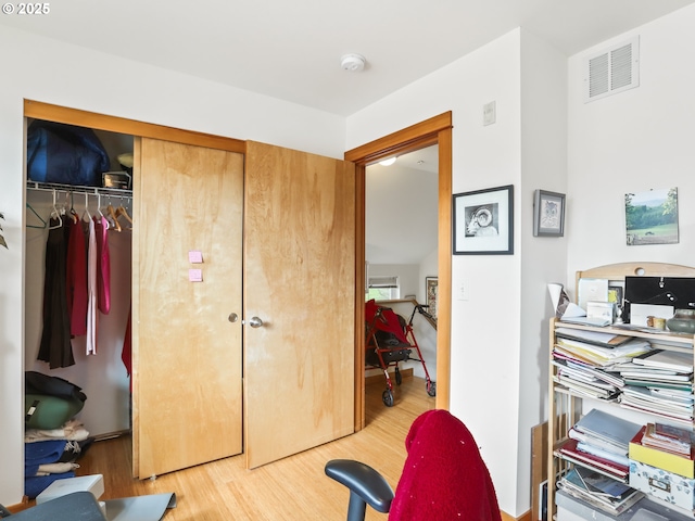 interior space with a closet, wood finished floors, and visible vents