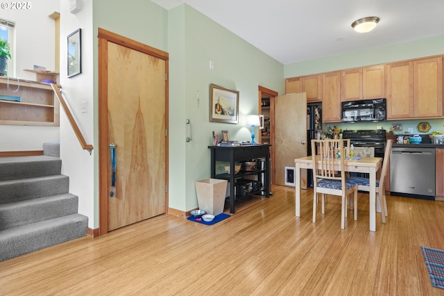 4475 N Trenton St Unit 101, Portland, OR 97203 - kitchen featuring black microwave, dishwasher, light wood-style flooring, stove, and dark countertops