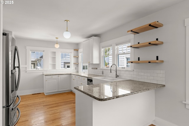 7505 SE 22nd Ave, Portland, OR 97202 - kitchen featuring open shelves, stainless steel appliances, a peninsula, a sink, and backsplash