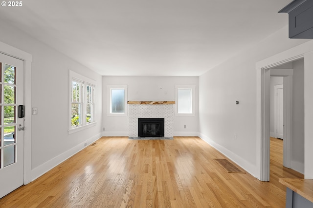 7505 SE 22nd Ave, Portland, OR 97202 - unfurnished living room featuring light wood-type flooring, baseboards, and a tiled fireplace