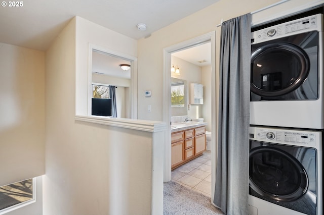 895 SW 170th Ave, Beaverton, OR 97006 - laundry area with stacked washer / dryer, a sink, light tile patterned floors, and light carpet