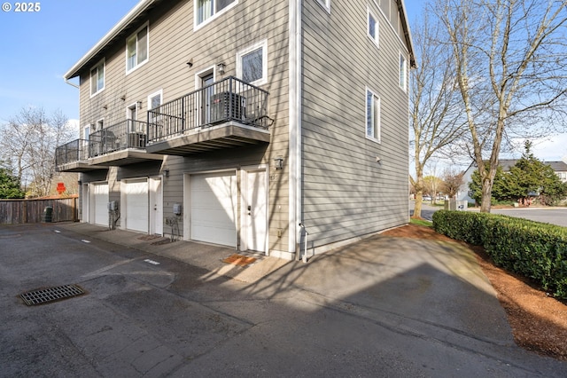 895 SW 170th Ave, Beaverton, OR 97006 - rear view of house featuring a balcony, asphalt driveway, and a garage