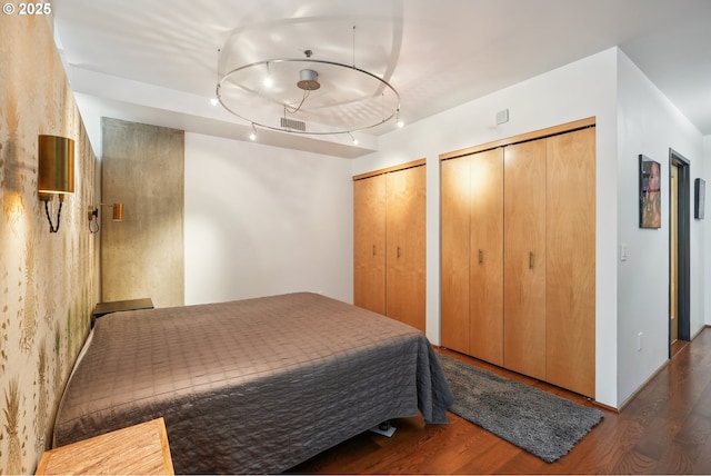 1221 SW 10th Ave Unit 410, Portland, OR 97205 - bedroom with wood finished floors, multiple closets, and track lighting