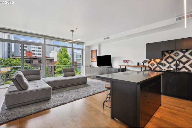 1221 SW 10th Ave Unit 410, Portland, OR 97205 - kitchen featuring open floor plan, dark countertops, light wood finished floors, a kitchen island, and expansive windows