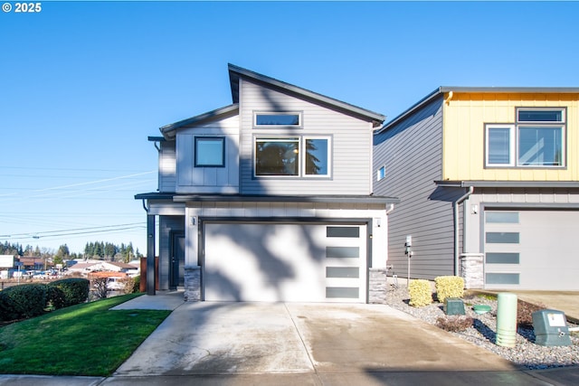 contemporary house featuring a front lawn, driveway, and an attached garage