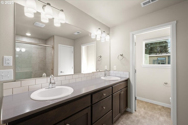 bathroom with visible vents, a sink, a shower stall, and double vanity