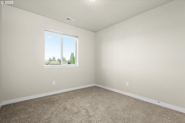 unfurnished room with carpet floors, visible vents, and baseboards