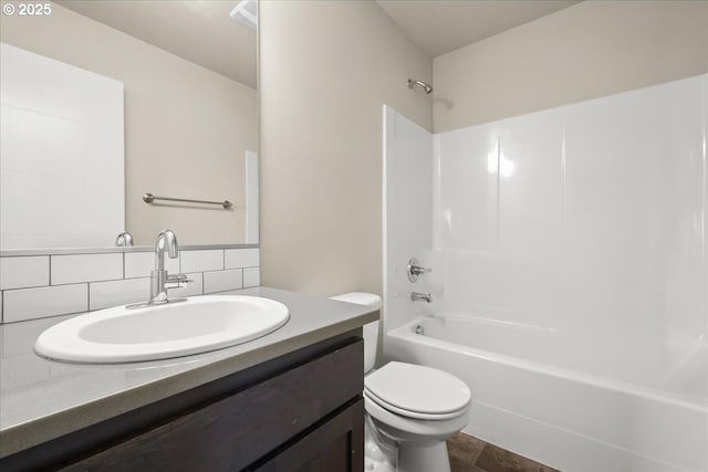 bathroom featuring vanity, backsplash, toilet, and bathing tub / shower combination