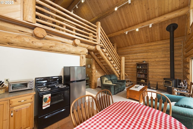 161 Acme Rd, White Salmon, WA 98672 - dining area with track lighting, a wood stove, wooden ceiling with exposed beams, rustic walls, and high vaulted ceiling