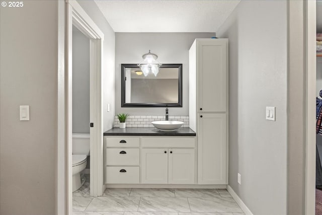 bathroom with toilet, a textured ceiling, and vanity