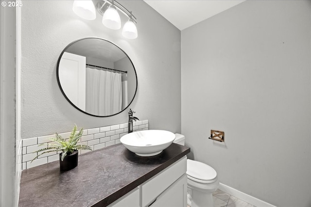 bathroom featuring backsplash, vanity, and toilet