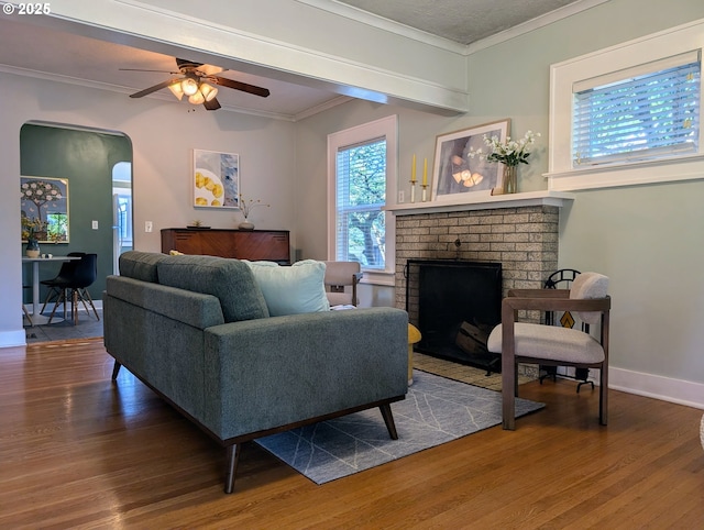 7035 NE Klickitat St NE, Portland, OR 97213 - living area featuring wood finished floors, ornamental molding, arched walkways, a fireplace, and ceiling fan