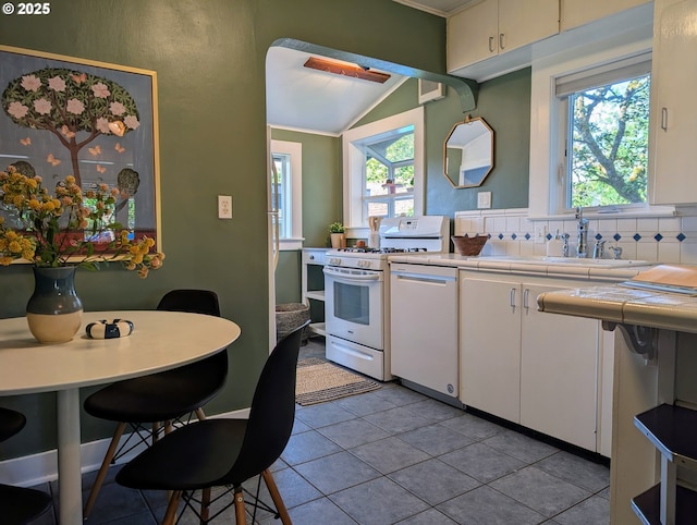 7035 NE Klickitat St NE, Portland, OR 97213 - kitchen with white appliances, a sink, tile counters, white cabinets, and lofted ceiling