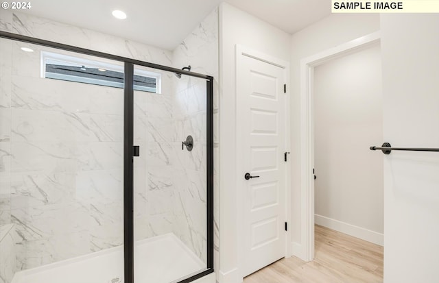 bathroom featuring hardwood / wood-style flooring and a shower with shower door