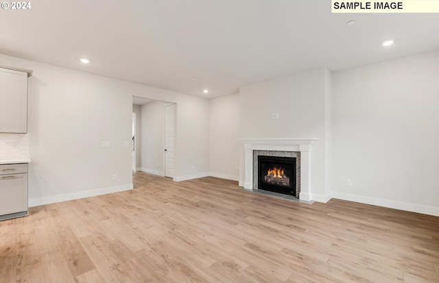 unfurnished living room with a fireplace and light hardwood / wood-style flooring