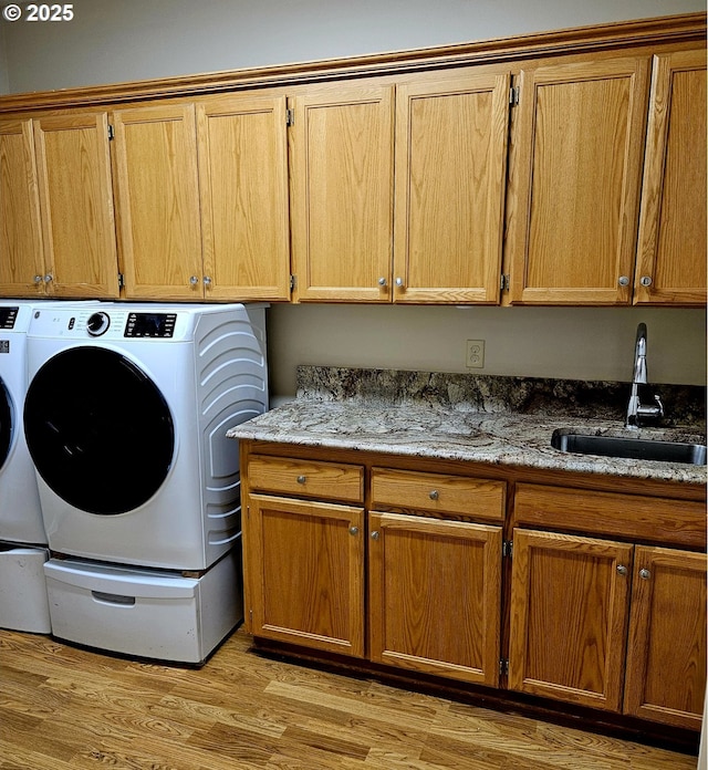 1270 Hidden Creek Dr, Keizer, OR 97303 - clothes washing area with cabinet space, washing machine and clothes dryer, and light wood-type flooring